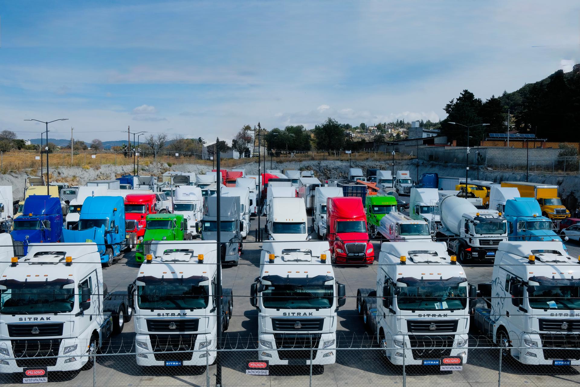 Fila de tractocamiones estacionados al atardecer